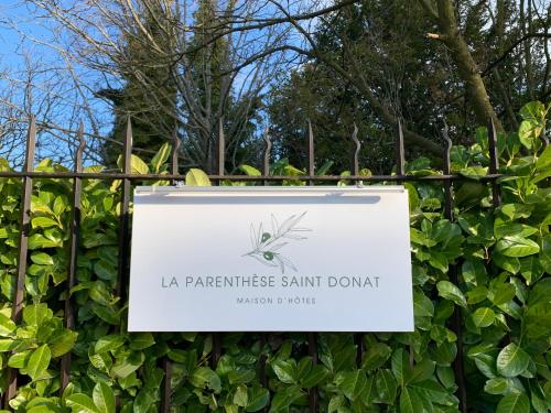 un panneau sur une clôture devant une plante dans l'établissement La Parenthese Saint Donat, à Aix-en-Provence