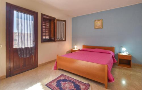 ein Schlafzimmer mit einem Bett mit einer rosa Decke und einer Tür in der Unterkunft 4 Bedroom Awesome Apartment In Trappeto in Trappeto