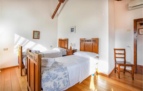 1 dormitorio con 2 camas y 1 silla en Stunning Home In Taglio Di Po Ro With 2 Bedrooms, Wifi And Outdoor Swimming Pool, en Porto Viro