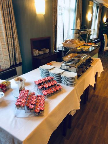 a table with plates and cupcakes on top at Vincent House London Residence in London