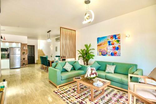 ein Wohnzimmer mit einem grünen Sofa und einem Tisch in der Unterkunft Hurghada Sahl Hasheesh sea-view Villa with private pool in Hurghada