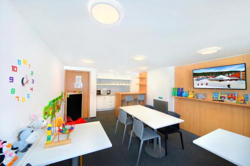a classroom with tables and chairs and a kitchen at Resort Špindl in Špindlerův Mlýn