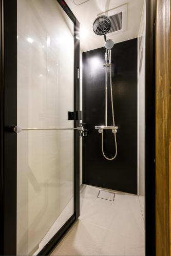 a shower with a glass door in a bathroom at HOTEL WOOD TAKAYAMA in Takayama