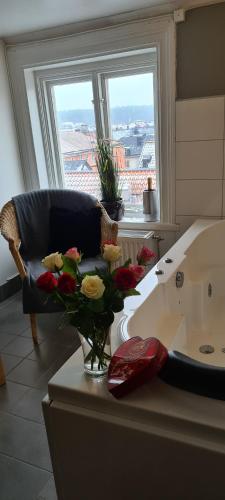 a bathroom with a couch and a vase of flowers on a counter at Arboga Stadshotell in Arboga