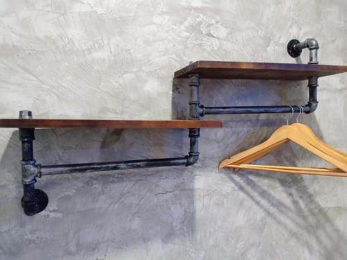 a wooden shelf on a wall with a hanger at Lanta smile inn in Ko Lanta