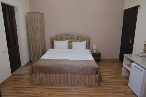 a bedroom with a bed with white sheets and pillows at H Resort Hotel Vagharshapat Armenia in Vagharshapat