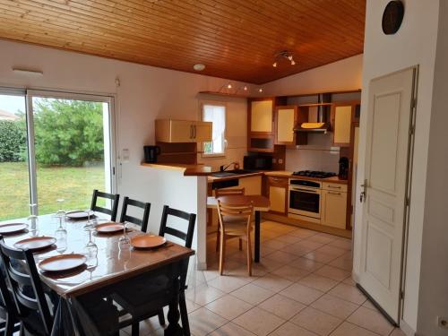 cocina con mesa con sillas y comedor en Maison des Trèmières, en Brem-sur-Mer