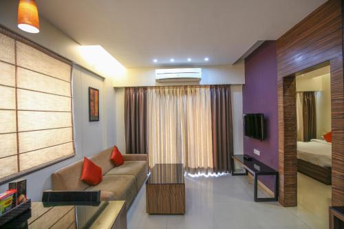 a living room with a couch and a bed at The Gold Haven in Pune