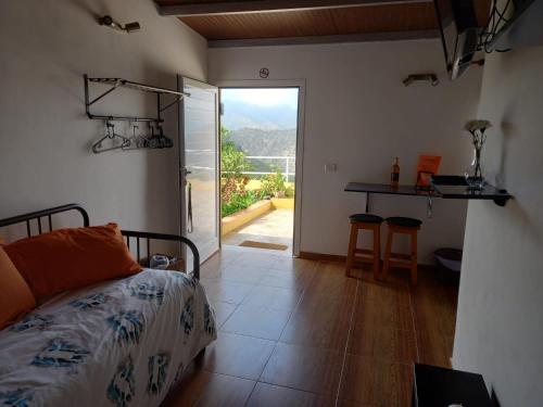 een slaapkamer met een bed en een deur naar een patio bij Orange House in Vallehermoso