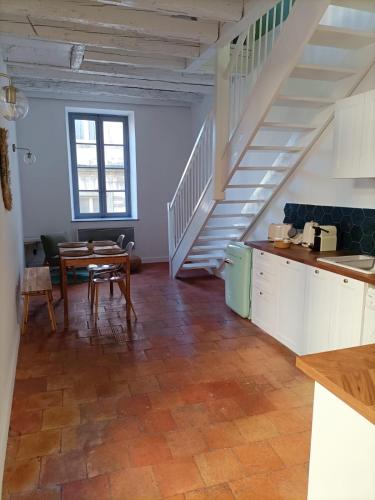 une cuisine avec un escalier et une table dans une pièce dans l'établissement La Dolce Vita, à Carcassonne
