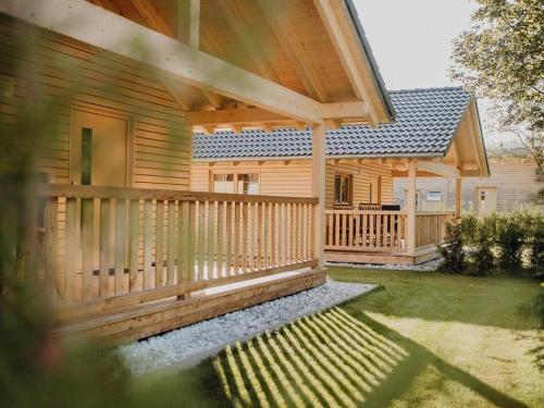 a wooden house with a porch and a deck at Natur-Camp Tannenfels in Baiersbronn