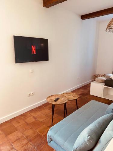 un salon avec un canapé et une télévision au mur dans l'établissement La Dolce Vita, à Carcassonne