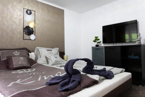 een slaapkamer met een bed met twee zwanen erop bij Komló Szíve Apartman in Komló