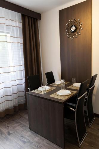 a conference room with a table with chairs and a chandelier at Komló Szíve Apartman in Komló