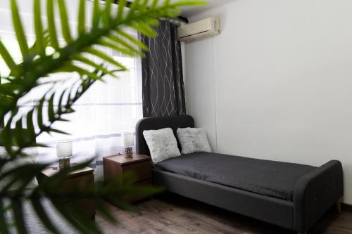 a living room with a couch and a window at Komló Szíve Apartman in Komló
