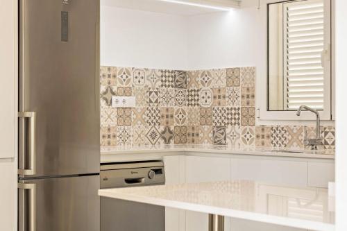 uma cozinha com armários brancos e um frigorífico de aço inoxidável em Casa del Monte em Santa Brígida