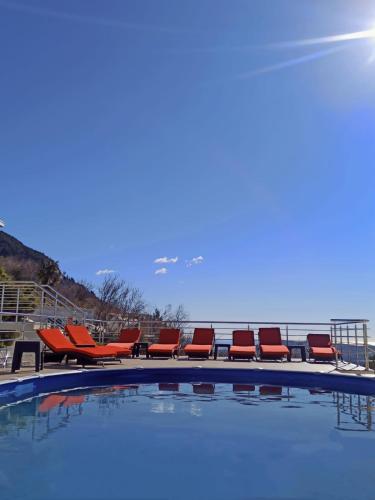 a row of chairs sitting next to a swimming pool at Villa Eagle Eye Montenegro in Kotor