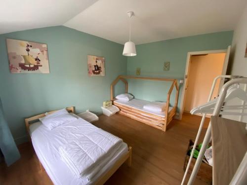 a bedroom with a bed and a bunk bed at Une maraîchine en bord de conche avec barque sans linge de maison in Arçais