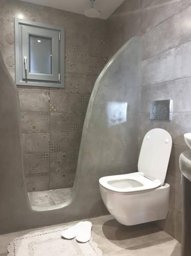 a bathroom with a toilet and a sink at Diavrouxas House in Sifnos in Cherronisos