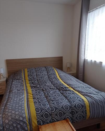 - un lit avec une couette bleue et jaune dans une chambre dans l'établissement Studio 