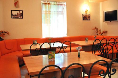 a living room with a couch and tables and chairs at Vidin Hotel in Vidin