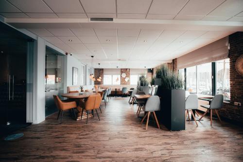 a restaurant with tables and chairs in a room at Strandhotel Zoutelande in Zoutelande