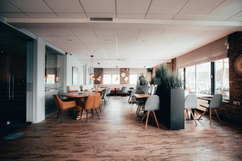 - un restaurant avec des tables et des chaises dans une salle dans l'établissement Strandhotel Zoutelande, à Zoutelande