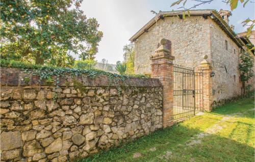 an old stone wall with a gate in front of a building at Il Glicine in Galzignano