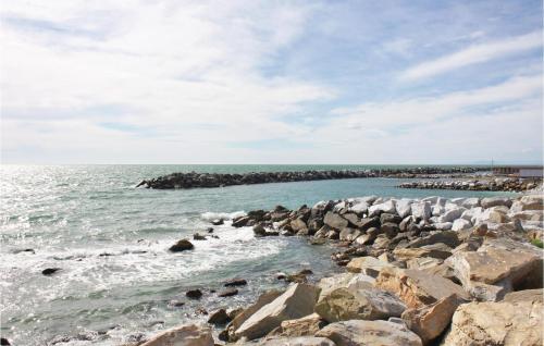 a beach with rocks and the ocean on a cloudy day at Il Kiwi in San Giovanni Alla Vena