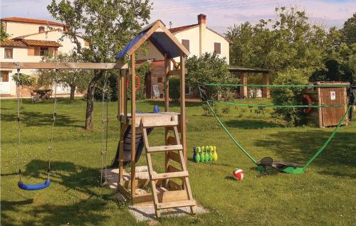 a wooden playset with a swing set in a yard at Il Kiwi in San Giovanni Alla Vena