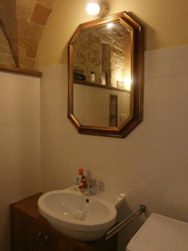 a bathroom with a sink and a mirror and a toilet at Lo Sfizio B&B in Cupramontana