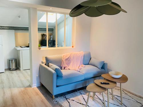 un salon avec un canapé bleu et deux tables dans l'établissement Le studio Hyper-centre, à Carcassonne