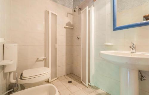a white bathroom with a toilet and a sink at Nice Apartment In Castiglione D,lago Pg With 1 Bedrooms, Wifi And Outdoor Swimming Pool in Strada