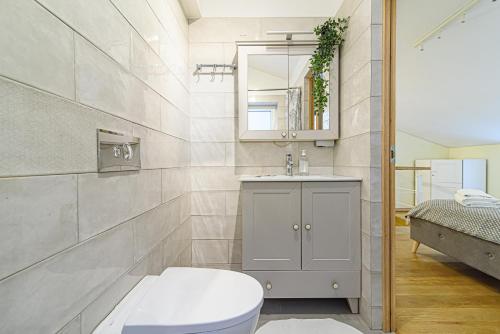 a bathroom with a toilet and a sink and a mirror at 2 floors New town apartment by URBAN RENT in Vilnius