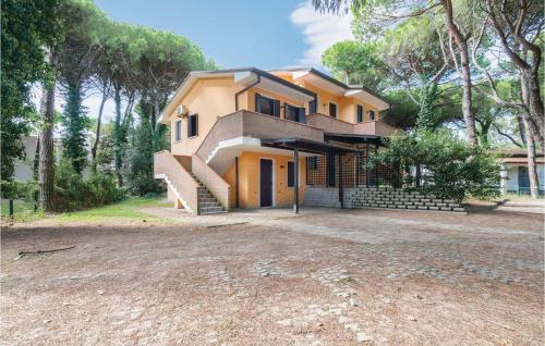 a yellow house with a staircase in front of it at Lovely Apartment In Rosolina Mare in Rosolina Mare