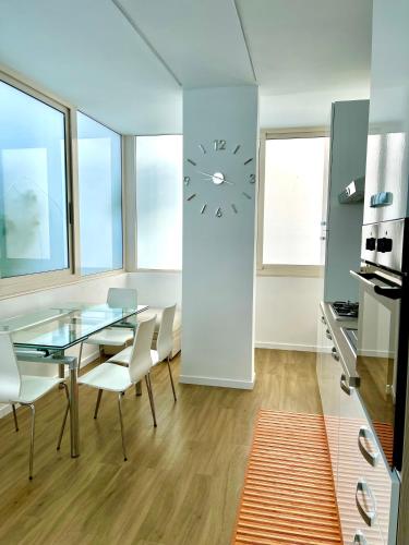 a dining room with a glass table and a clock at Oasi del Mare… in Ortona