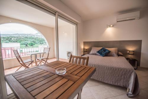 une chambre avec un lit et une table dans l'établissement Les Alizés Résidence & Spa, à Monticello