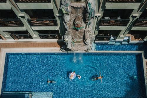 two people swimming in a pool with a water slide at Ananta Burin Resort in Ao Nang Beach