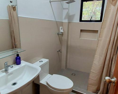 e bagno con servizi igienici, lavandino e doccia. di Le Chateau Residences a Bacolod