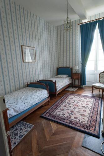 une chambre avec deux lits et un tapis dans l'établissement Domaine de Lalande, à Vénès