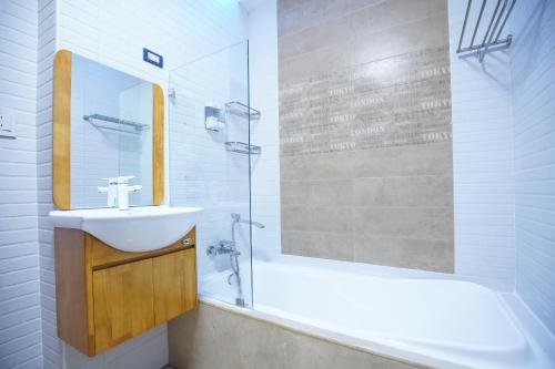 a white bathroom with a sink and a shower at CLOCKWORKORANGE Luxury Suites 4-Minutes Away To Airport in Mactan