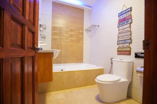 a bathroom with a toilet and a bath tub at CLOCKWORKORANGE Luxury Suites 4-Minutes Away To Airport in Mactan