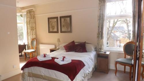 a bedroom with a bed with two towels on it at Cedar House B&B in Matlock