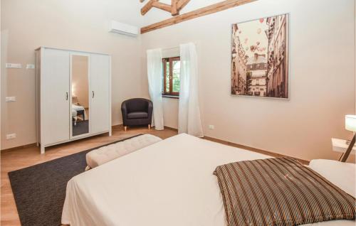 a bedroom with a bed and a chair and a mirror at Nice Home In Fabrica Di Roma -lt- With 2 Bedrooms in Fabrica di Roma