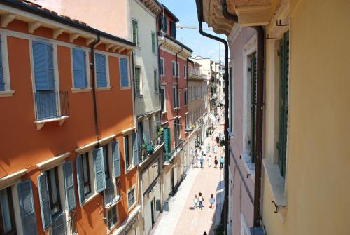 ヴェローナにあるResidenza Tre Marchettiの建物間を歩く人々