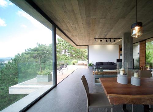a dining room and living room with a large glass window at La Villa Da Lat in Khu Chi Lăng