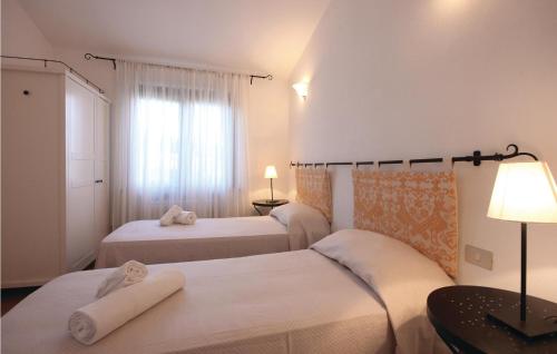 モンテ・ナイにあるStunning Home In Costa Rei -ca- With 3 Bedrooms And Wifiのベッド2台と窓が備わるホテルルームです。