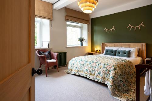 a bedroom with a bed and a green wall at Mint Mill: New riverside apartment in historic mill in Kendal