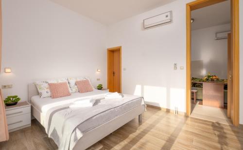 a white bedroom with a large bed in it at Studio Apartment Brigita in Mlini