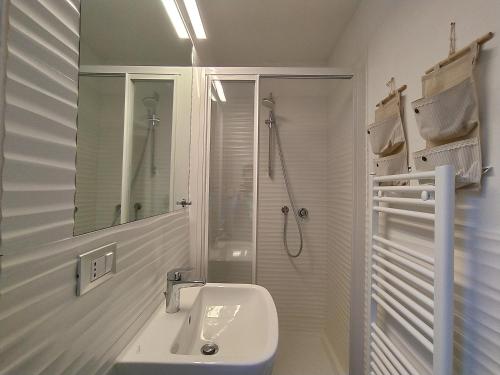 a white bathroom with a sink and a shower at Rosanna House in Vernazza